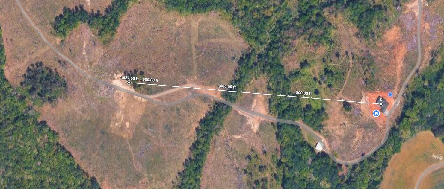 Satellite view showing the 1,627 foot distance between the house and the pasture camera, crossing two wooded hills